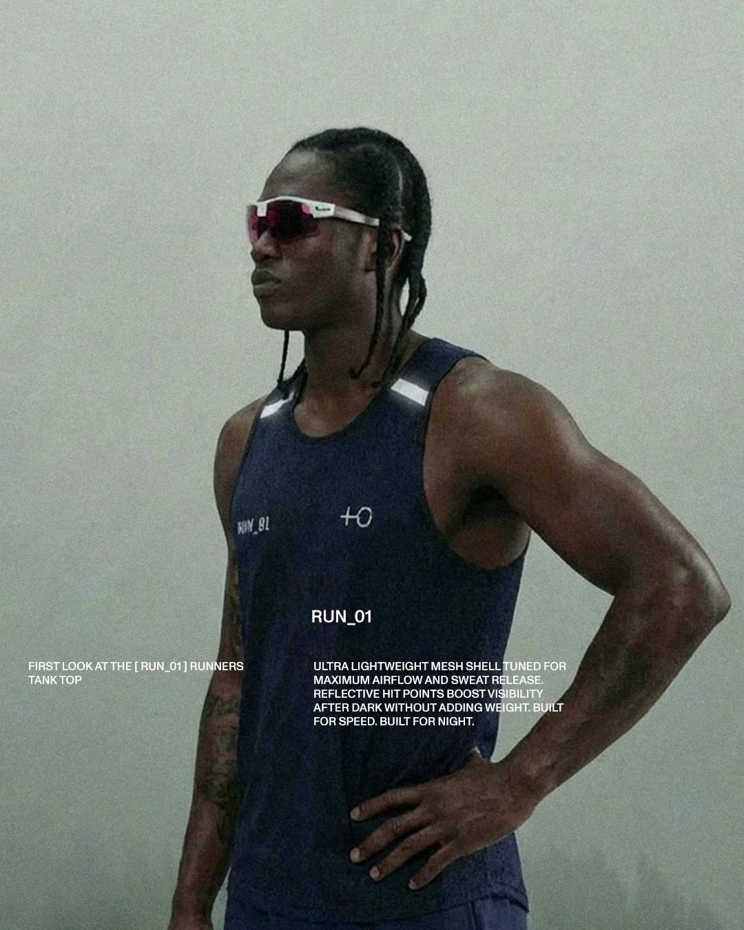 Athletic man wearing reflective navy runner's tank top and sporty sunglasses in studio