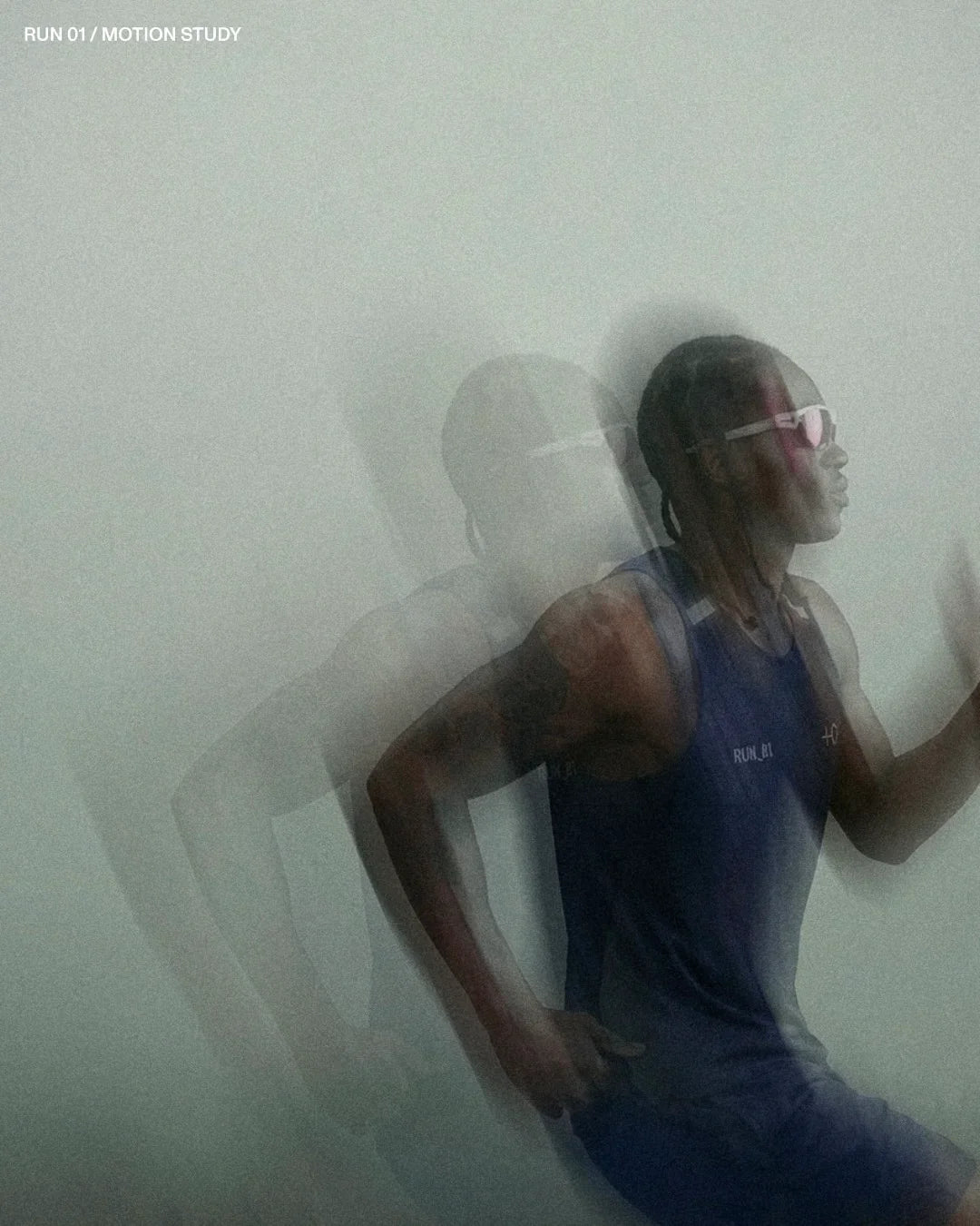Motion study of a male runner in blue athletic gear and sunglasses against a gray background